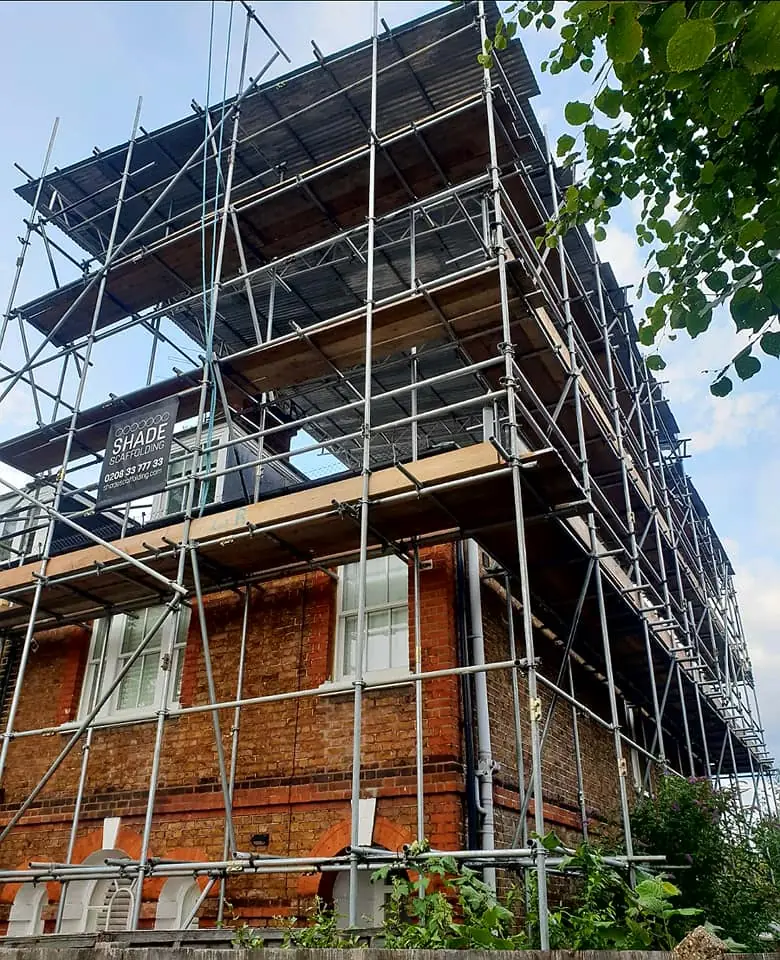 A brick house scaffolded around its corner
